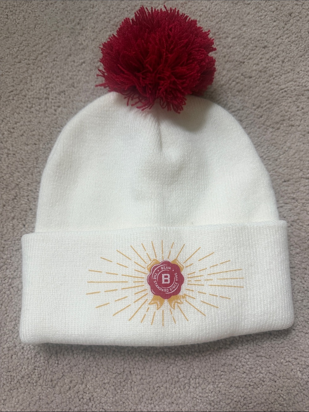Cream Knit Pom Beanie with Red Pom and Gold Sunburst Accent